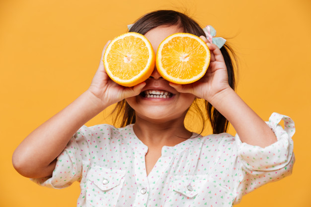 little-girl-child-covering-eyes-with-orange_171337-3409