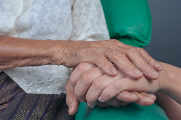 young-woman-holding-elderly-woman-s-hand_1150-12495