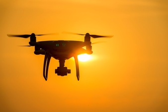 silhouette-drone-with-camera-flying-sunset_335224-924