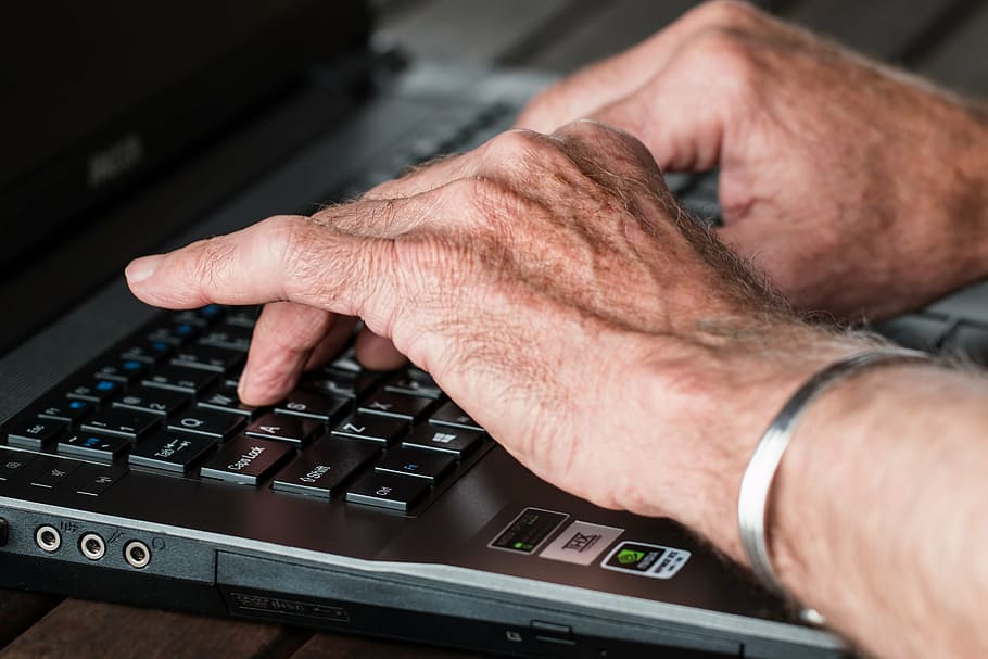 hands-old-typing-laptop