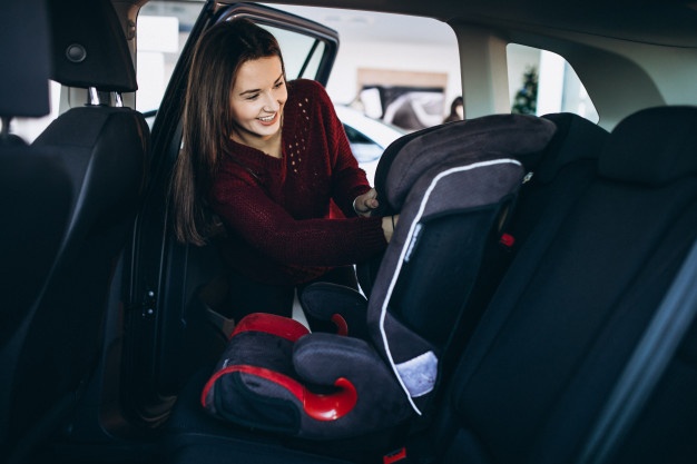 car seat baby woman-installing-safety-car-sit-into-car_1303-19221
